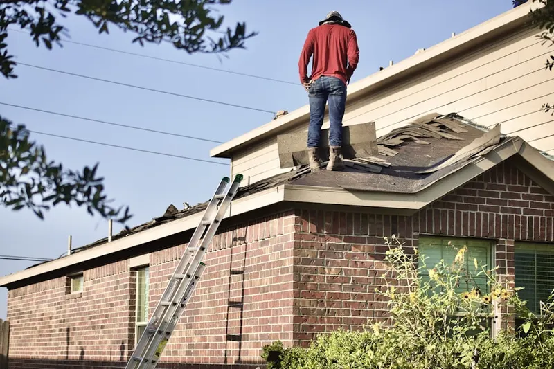 Professional roofer working on a residential roof in South River Gardens